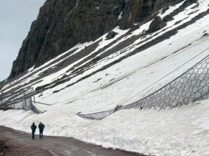 Mallas de protección deformadas junto a una ladera nevada en el camino hacia el Embalse El Yeso